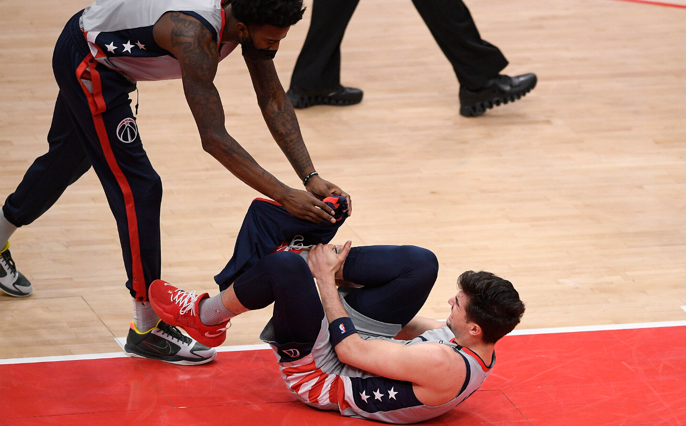 Deni Avdija receives treatment after suffering an injury on the basketball court